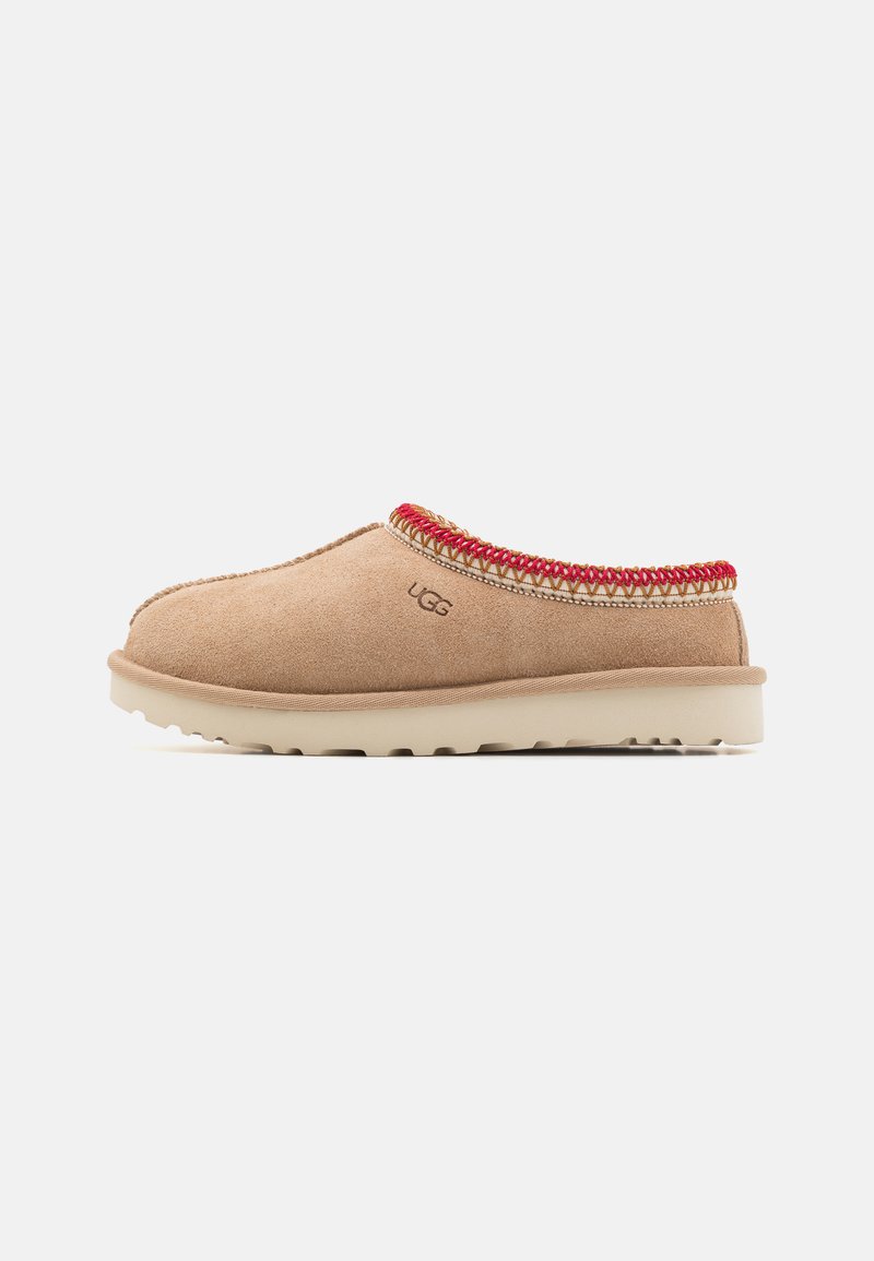 Beige suede slip-on shoe with red woven accents around the collar, textured sole, and light cushioning for comfort.