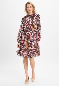 Langere jurk met een gatherede hals, elastische taille en een gedurfde, abstracte roze en bruine patroon op doorschijnende stof, afgewerkt met een zwierig zoom.