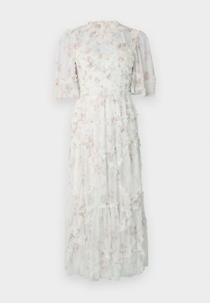 Abito lungo in tessuto bianco trasparente con motivo floreale pastello, strati arricciati e maniche a sbuffo. Presenta una vita aderente e chiusura posteriore con zip.