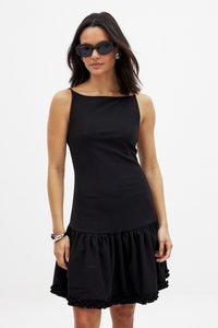 Vestido negro sin mangas con un corpiño ajustado y un dobladillo con volantes. Hecho de una tela suave con una falda acampanada, presenta un diseño simple y limpio.