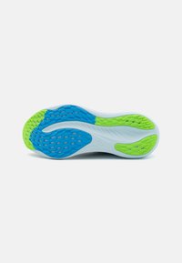 Suola della scarpa con una base bianca, caratterizzata da modelli di presa in gomma blu e verde. Superficie testurizzata con forme variate per una trazione migliorata.