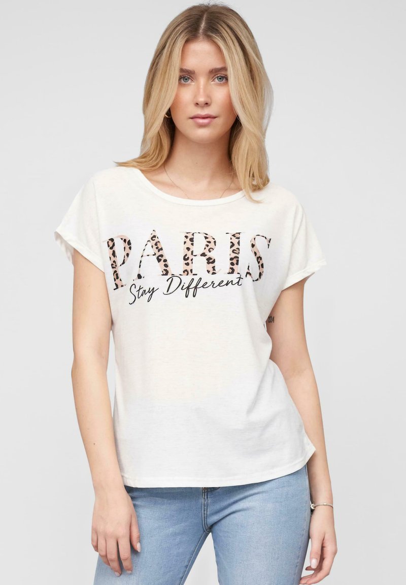 T-shirt en coton blanc à manches courtes et encolure ronde, affichant "PARIS" en imprimé léopard et "Restez Différent" en script noir en dessous.