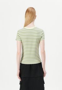 Pasiasty t-shirt z krótkim rękawem w jasnym zielonym i białym kolorze, o dopasowanym kroju i okrągłym dekolcie, wyeksponowany z tyłu.