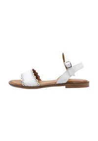 Sandalia de cuero blanco con bordes en forma de olas, correa ajustable en el tobillo y plantilla de cuero marrón. Suela plana con textura de madera natural.