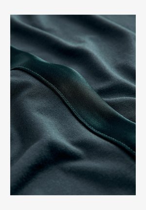 Dark green fabric with a smooth texture and a glossy satin stripe. The fabric is slightly wrinkled, highlighting its soft drape.