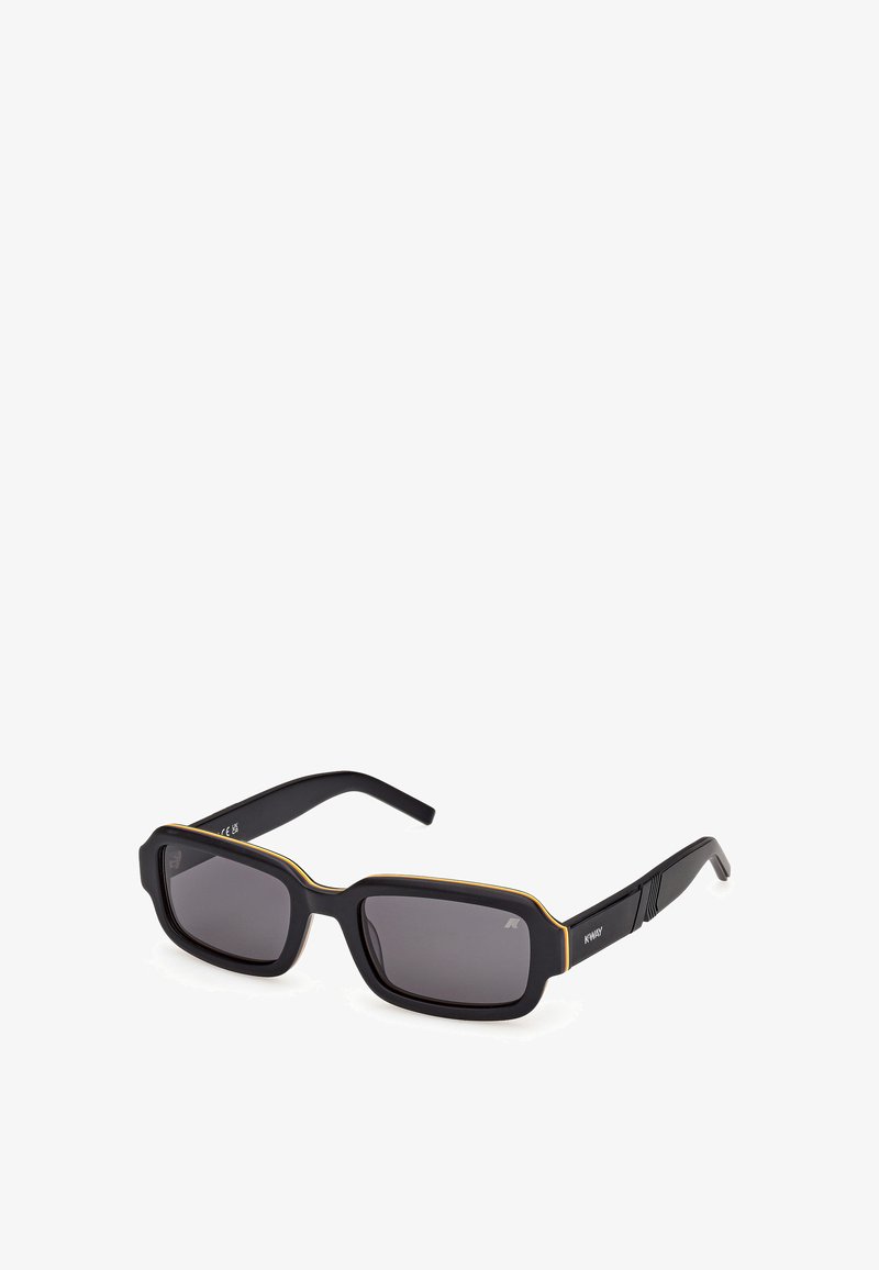 Gafas de sol negras con forma rectangular. Textura mate, acento dorado a lo largo del borde y lentes grises. Patillas negras resistentes con detalle de marca.