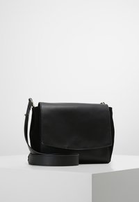 Borsa a tracolla in pelle nera con pattina pieghevole, tracolla regolabile e superficie liscia. Il design minimalista non presenta motivi evidenti.