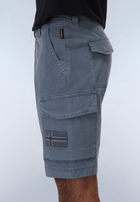 Gray cargo shorts made of durable fabric, featuring multiple pockets, a patch with a horizontal stripe design, and a relaxed fit.