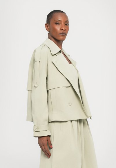 Light green double-breasted jacket with large lapels and shoulder epaulettes. Features buttoned cuffs and a relaxed fit. Smooth texture.