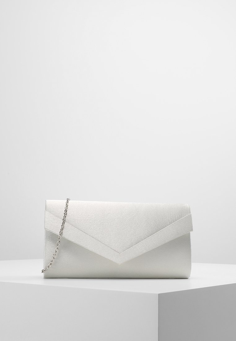 Bolso de mano de satén blanco con una cadena plateada, descansando sobre un pedestal blanco contra un fondo gris.