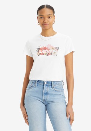 White cotton t-shirt featuring a floral graphic with "Levi's" text, short sleeves, and a classic crew neck design. Worn with blue high-waisted jeans.