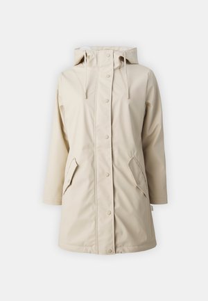 Veste beige imperméable avec capuche, boutons-pression et deux poches avant angulaires. Elle présente une texture lisse et une coupe décontractée.