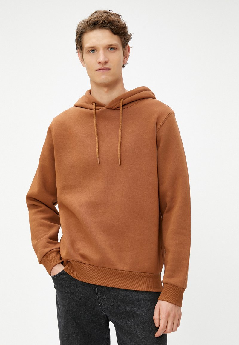 Bruine hoodie met een koord, gemaakt van zachte stof. Bevat een buidelzak en ribgebreide manchetten en zoom. Casual pasvorm, geen zichtbare patronen.