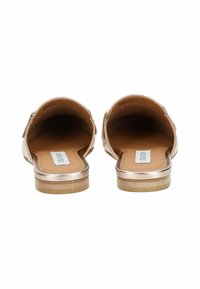 Sandali slip-on metallici oro con finitura in pelle liscia, schiena aperta e suola piatta in legno, caratterizzati da un design minimalista e senza hardware visibile.