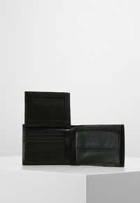 Portafoglio in pelle nera con finitura texturizzata, numerosi scomparti per carte e un portadocumenti trasparente. Design pieghevole con interno liscio.