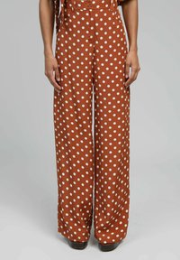 Pantalons à larges jambes marron à pois, fabriqués en tissu doux, présentant de grands pois blancs, taille haute et coupe décontractée ; poches latérales incluses.