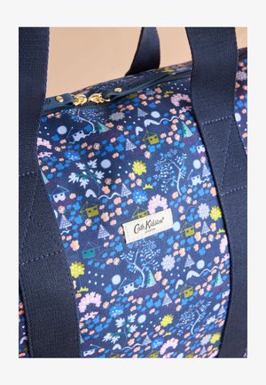 Naktaudzis zils Cath Kidston soma ar ziedu un mājas rakstu, zelta krāsas rāvējslēdzēja vilcējiem un izturīgiem tumši zilajiem rokturiem.