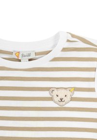 Camisa de manga corta a rayas en blanco y beige. Presenta una cara de oso bordada y una etiqueta de logo en el cuello. Textura de algodón suave.
