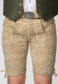 Beige leren shorts met bloemige borduursels en zijzakken, voorzien van een decoratieve zilveren gesp en banden bij de manchetten.