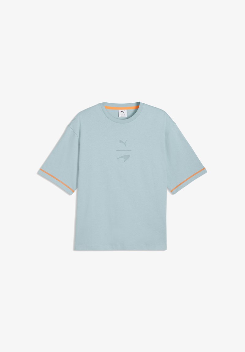 Hele sinine Puma lühikeste varrukatega T-särk oranžide ääretega varrukatel ja krae juures, rinnal peened Puma ja McLareni logod.