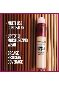 Correttore multiuso Maybelline Eraser in un tubo trasparente con applicatore a spugna rosa e cappuccio rosso; presenta evidenziazioni di testo e uno sfondo in legno.