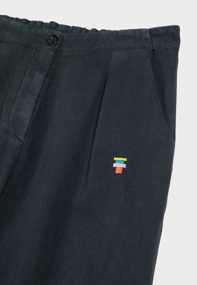Pantaloni verde scuro in tessuto morbido, con frontale piatto e tasche laterali. Logo ricamato in piccole forme geometriche multicolori.