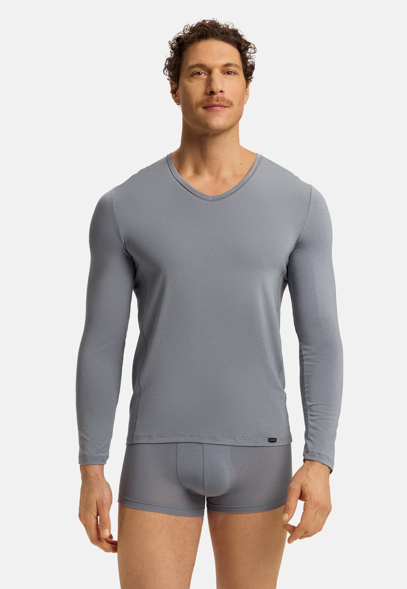 Lichte grijze V-hals lange mouwen shirt, aangesloten ontwerp, gladde textuur, gecombineerd met bijpassende aangesloten shorts; minimale merkaanduiding.