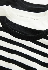 Set di tre T-shirt: una nera unita, una bianca e una con righe bianche e nere. Tutte hanno colli a girocollo ribattuti e una texture di tessuto morbido.
