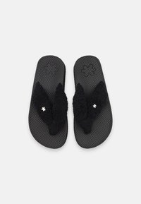 Black flip-flops with textured rubber soles and fuzzy black straps, featuring a small metallic star accent on one strap.