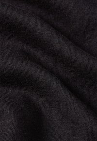Tissu noir avec une texture lisse et douce, présentant un motif de tricot fin et un éclat subtil, les plis créant de douces ondulations pour une profondeur visuelle.