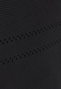 Tissu côtelé noir avec deux rangées horizontales de petites perforations uniformément espacées créant un motif subtil.