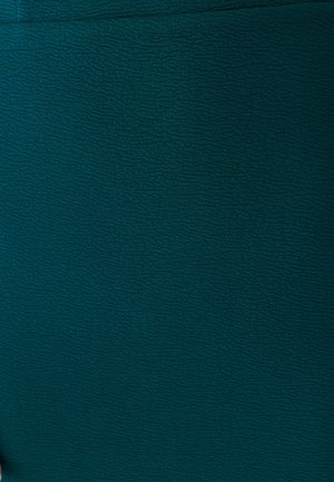 Tissu texturé en bleu sarcelle avec un motif de vagues continu et une surface lisse. Aucun matériel visible ni accents supplémentaires.