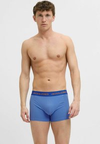 Kék pamut boxer nadrág, rugalmas derékkal, narancssárga "JACK & JONES" felirattal. Simább textúra és testhez simuló kialakítás.