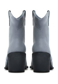 Botines de ante gris con puntera afilada, superficie texturizada y tacones de bloque negros. Incluyen tiradores para facilitar el uso.