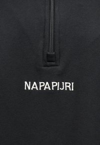 Μαύρο ύφασμα με μισό φερμουάρ και λευκή κεντητή επιγραφή "NAPAPIJRI" κάτω από το φερμουάρ.