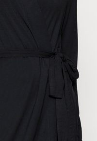 Svart omslagskjole laget av mykt stoff, med et belte i midjen og en jevn tekstur med draperingsdetaljer.