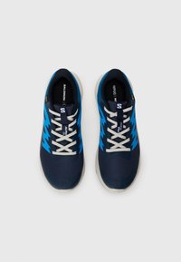 Baskets de sport bleu marine avec des accents bleus, tige en mesh, lacets blancs et semelle en caoutchouc ; arborant un logo sur le côté et sur la languette.