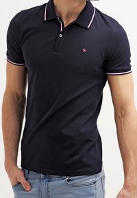 Polo navy con cuello de rayas rosas, mangas cortas y un pequeño logo en el pecho. Hecho de una suave tela de algodón, diseño ajustado.