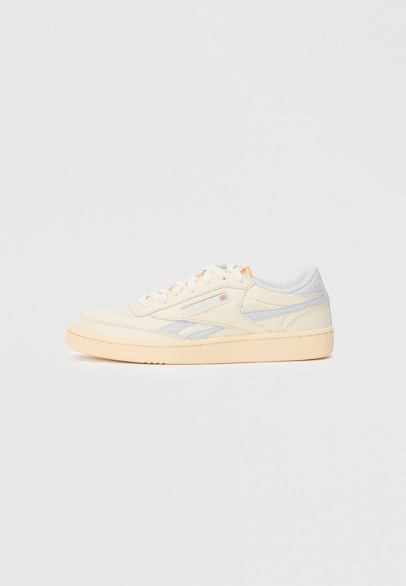 Kreemja ja heledat halli madala profila sneakersid, mis on valmistatud siledast nahast, sisaldavad diskreetset brändimist ja kummist tallat, ümarate varvaste ja nööbitava disainiga.