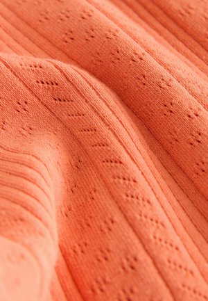 Korallenfarbiger Strickstoff mit strukturierten Mustern und vertikalen Rippen, der eine weiche Textur mit zarten Lochmustern zeigt.