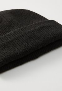 Bonnet en tricot noir avec une texture côtelée, doté d'un revers replié. Fabriqué en tissu doux et chaud.