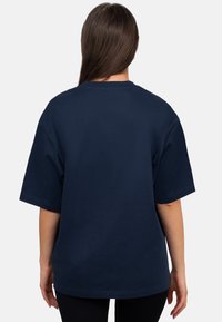 T-shirt bleu marine à manches courtes en coton, avec un col rond et une coupe décontractée, sans graphiques ni embellissements visibles.