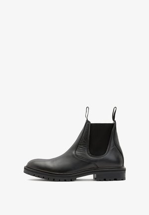 Czarne skórzane botki Chelsea z elastycznymi panelami bocznymi, pętelkami do zakupu i solidną gumową podeszwą, z okrągłym noskiem i gładką teksturą.