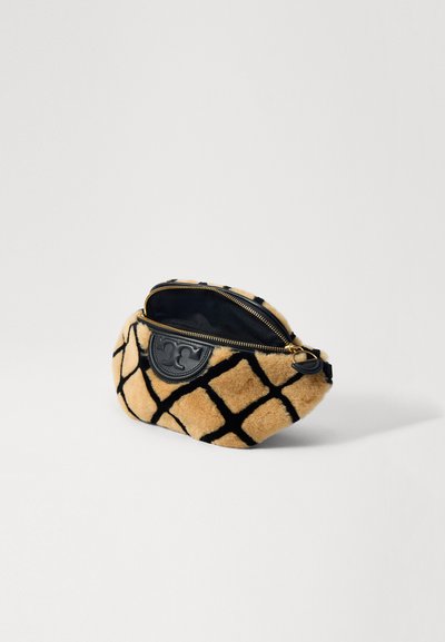 Pochette en fausse fourrure brune avec un motif en grille noire, présentant un patch en cuir noir avec logo, fermeture éclair, et texture douce.