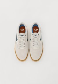 Bílé kožené tenisky se semišovými akcenty, námořnická značka, béžová guma a červené vložky s logem "NIKE 58".