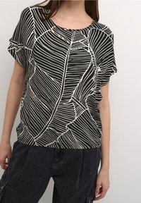 Schwarzes Oberteil mit weißem Blattmuster, kurzen Ärmeln, rundem Ausschnitt, weiter Passform, glatter Textur, kombiniert mit dunklen Cargohosen.