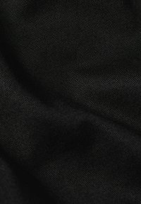 Tessuto nero con una trama sottile, caratterizzato da una superficie liscia e da un motivo di tessitura uniforme. Il materiale è leggero e flessibile.