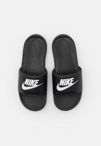 Fekete papucsok texturált talppal és széles pánttal, amelyen a fehér Nike logó látható. Szintetikus anyagból készült.