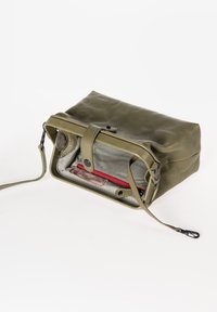 Borsa in pelle verde oliva con chiusura a zip; l'interno presenta una fodera a righe e una tasca con zip rossa. Include una tracolla rimovibile.
