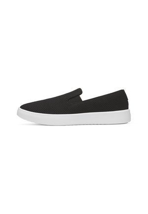 Sneaker nero slip-on con tomaia in tessuto strutturato e suola spessa in gomma bianca, mostrato di profilo su sfondo bianco.